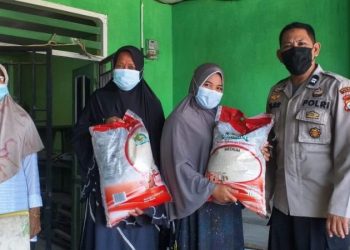 Bhabinkamtibmas Barombong Jaga Pembagian Bansos Beras PPKM Kepada Warga Terdampak Covid-19