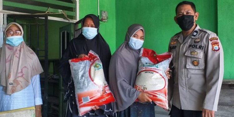 Bhabinkamtibmas Barombong Jaga Pembagian Bansos Beras PPKM Kepada Warga Terdampak Covid-19